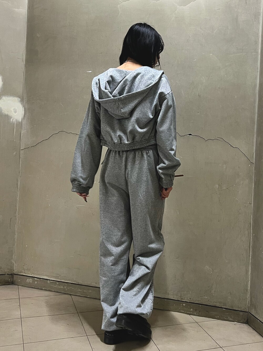 グレー系のスウェットパンツ、グレー系のパーカー、ブラック系のキャミソールを着用したレディースの春コーディネートの3枚目の写真