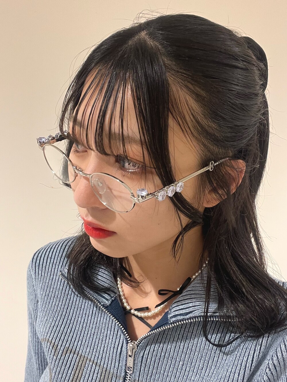 ブルー系のニット/セーター、ホワイト系のその他パンツ、シルバー系のメガネを着用したレディースの春コーディネートの9枚目の写真