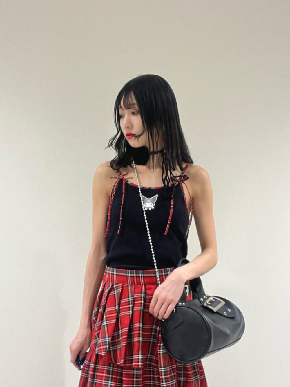 ブラック系のキャミソール、レッド系のスカート、ブラック系のボストンバッグを着用したレディースの春コーディネートの4枚目の写真