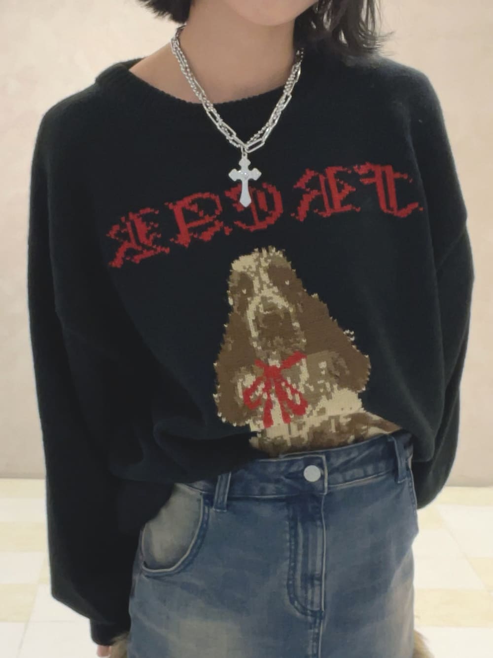 ブラック系のニット/セーター、ブルー系のスカート、ブラック系のブーツを着用したレディースの秋コーディネートの5枚目の写真