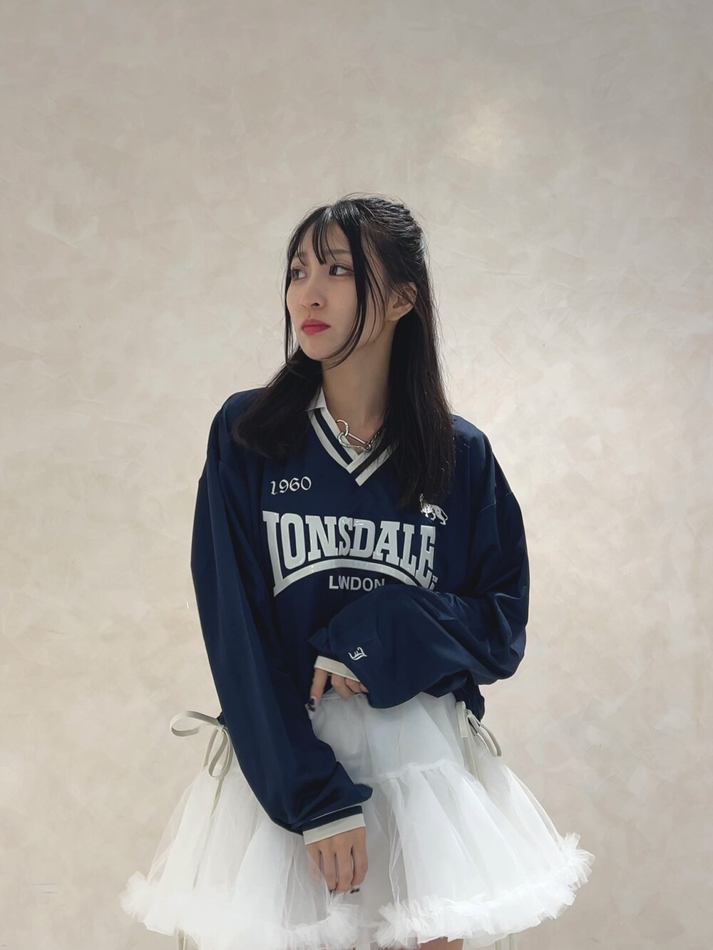 ブルー系のTシャツ/カットソー、ホワイト系のスカート、ブラック系のブーツを着用したレディースの秋コーディネートの4枚目の写真