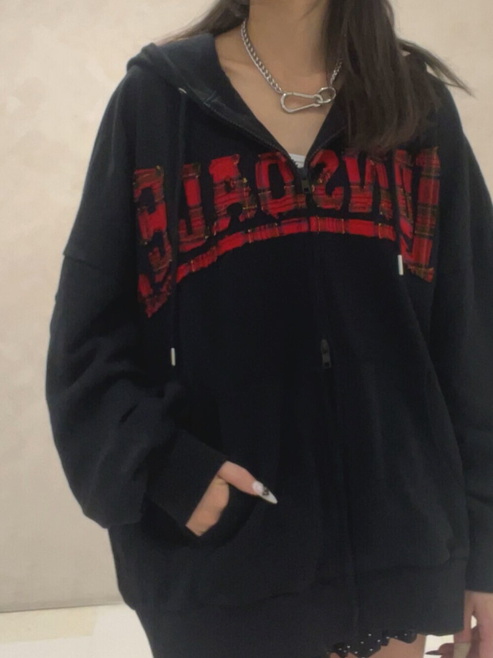 ブラック系のブーツ、ブラック系のパーカー、ブラック系のスカートを着用したレディースの秋コーディネートの5枚目の写真