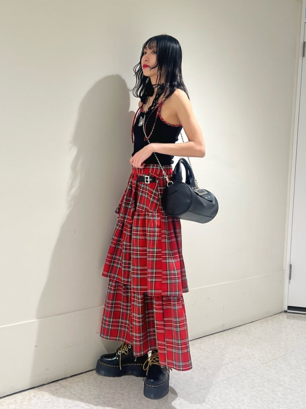 ブラック系のキャミソール、レッド系のスカート、ブラック系のボストンバッグを着用したレディースの春コーディネートの2枚目の写真