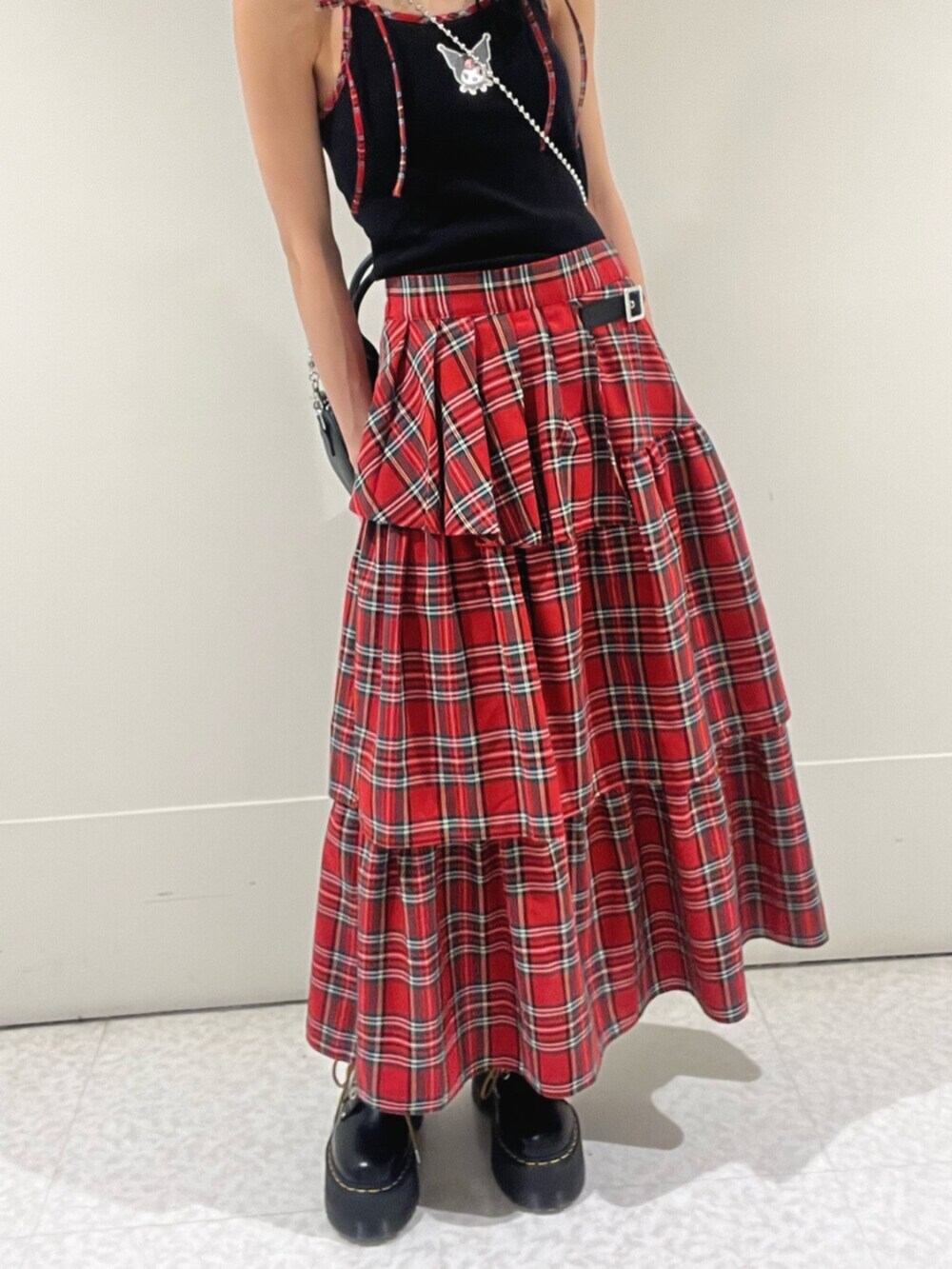 ブラック系のキャミソール、レッド系のスカート、ブラック系のボストンバッグを着用したレディースの春コーディネートの6枚目の写真