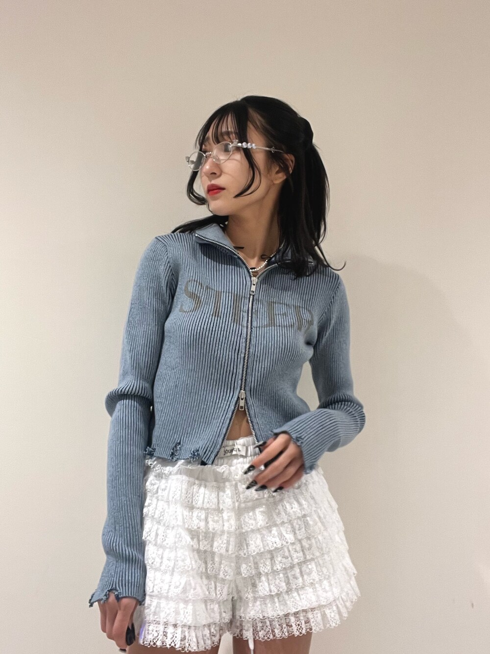 ブルー系のニット/セーター、ホワイト系のその他パンツ、シルバー系のメガネを着用したレディースの春コーディネートの4枚目の写真