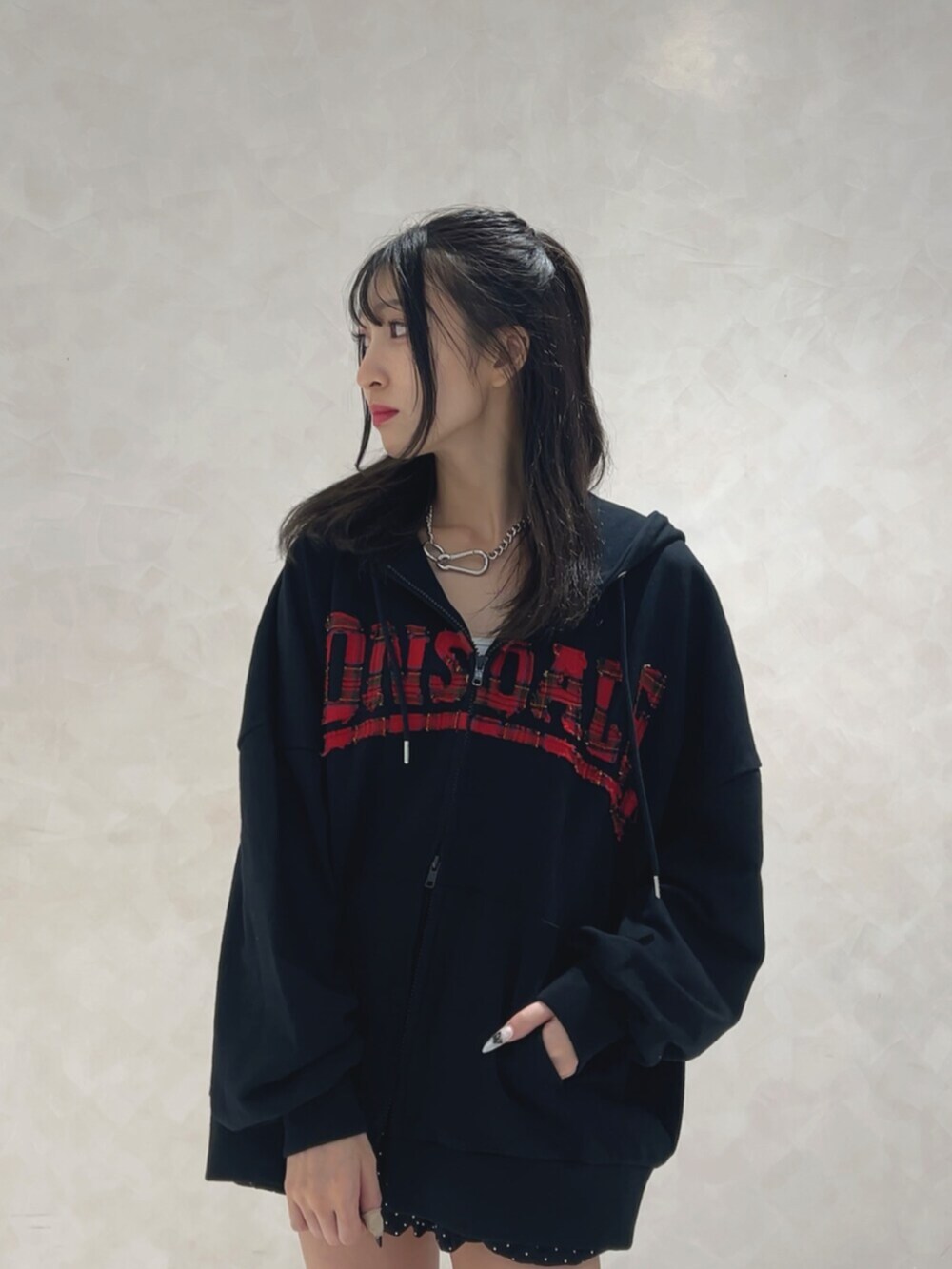 ブラック系のブーツ、ブラック系のパーカー、ブラック系のスカートを着用したレディースの秋コーディネートの4枚目の写真