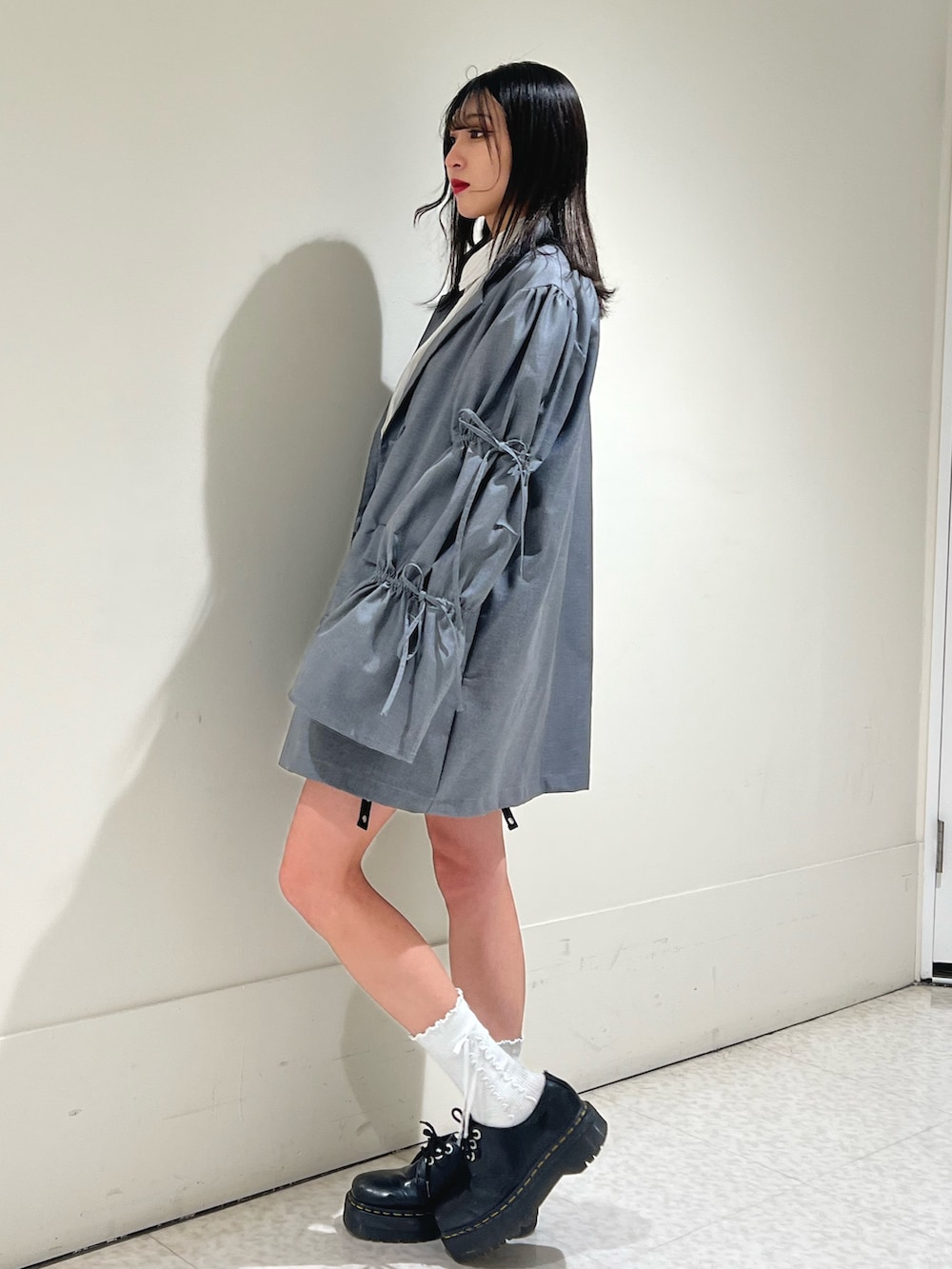 ブラック系のスカート、グレー系のワンピース、ホワイト系のシャツ/ブラウスを着用したレディースの春コーディネートの2枚目の写真