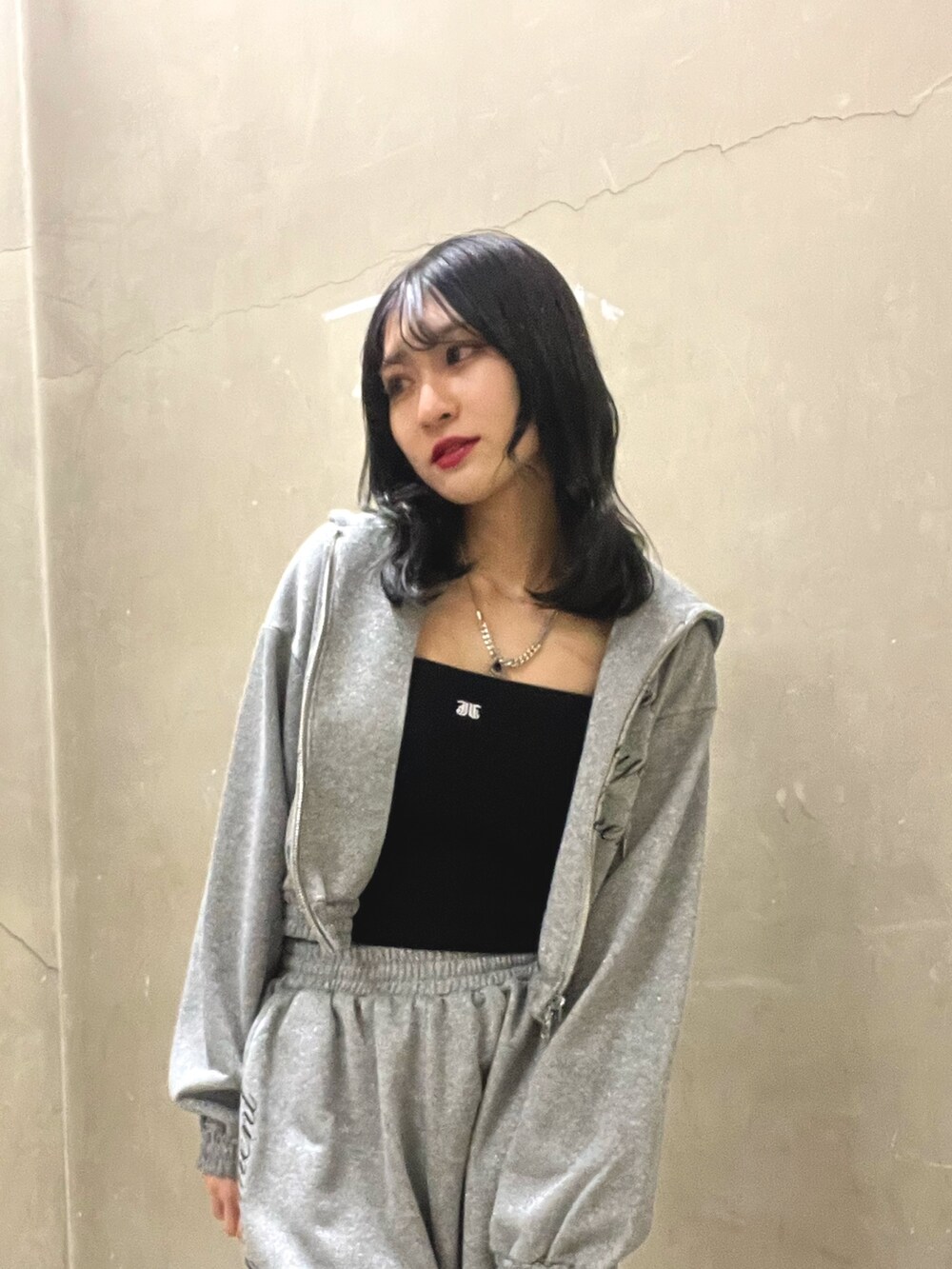 グレー系のスウェットパンツ、グレー系のパーカー、ブラック系のキャミソールを着用したレディースの春コーディネートの4枚目の写真
