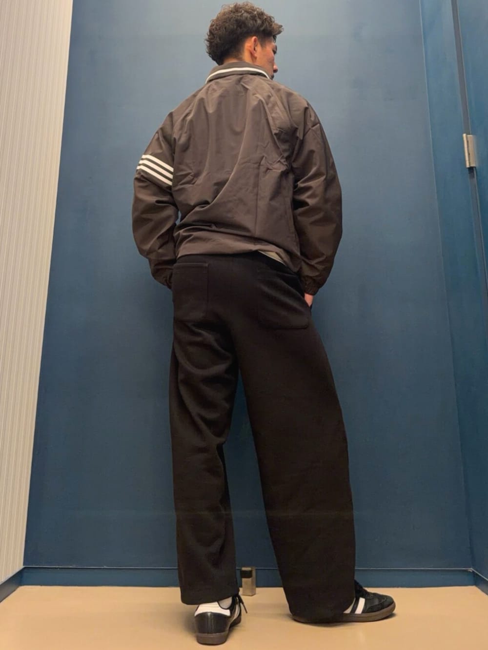 ホワイト系のTシャツ/カットソー、ブラウン系のナイロンジャケットを着用したメンズの秋コーディネートの2枚目の写真