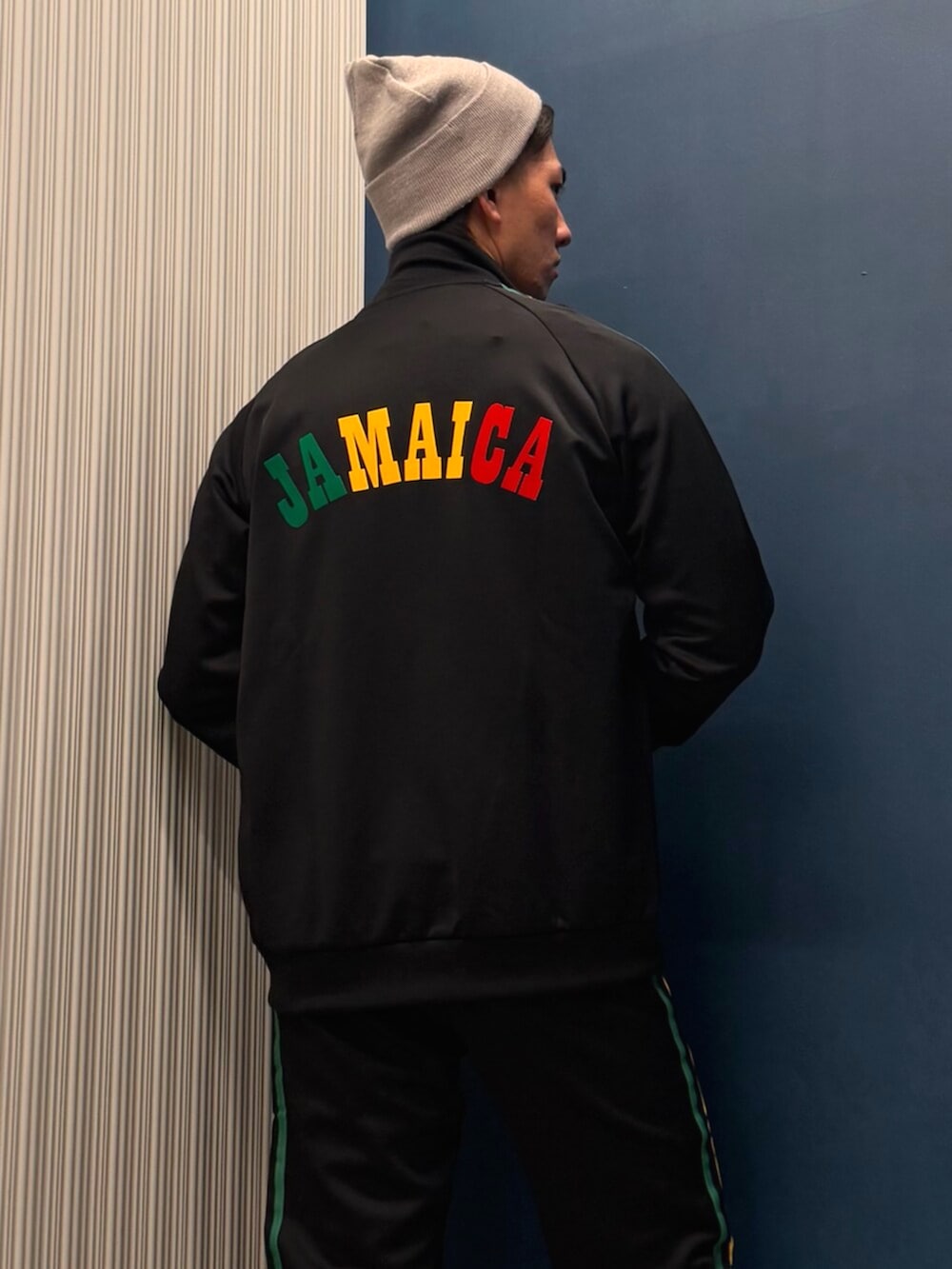 グリーン系のトップス、ブラック系のジャージ、ブラック系のスウェットパンツを着用したメンズの春コーディネートの4枚目の写真