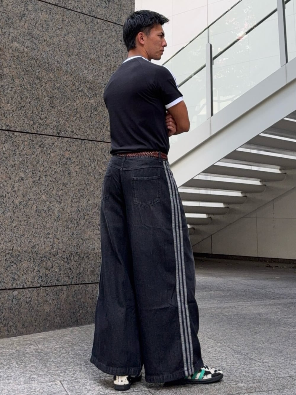 ブラック系のデニムパンツ、ブラック系のトップス、ブラック系のスニーカーを着用したメンズの夏コーディネートの2枚目の写真