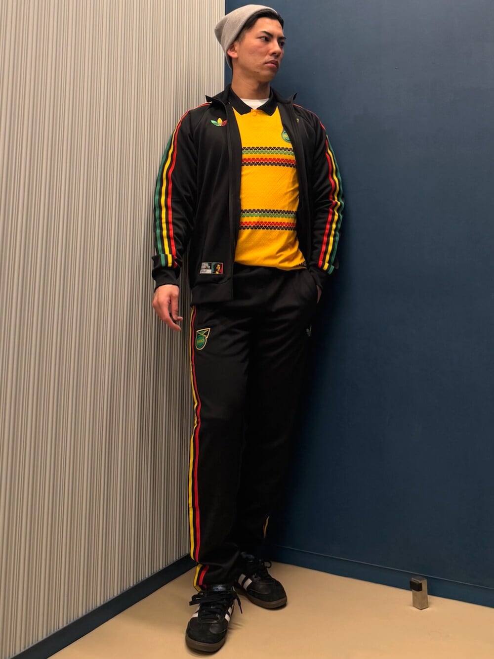 グリーン系のトップス、ブラック系のジャージ、ブラック系のスウェットパンツを着用したメンズの春コーディネートの3枚目の写真