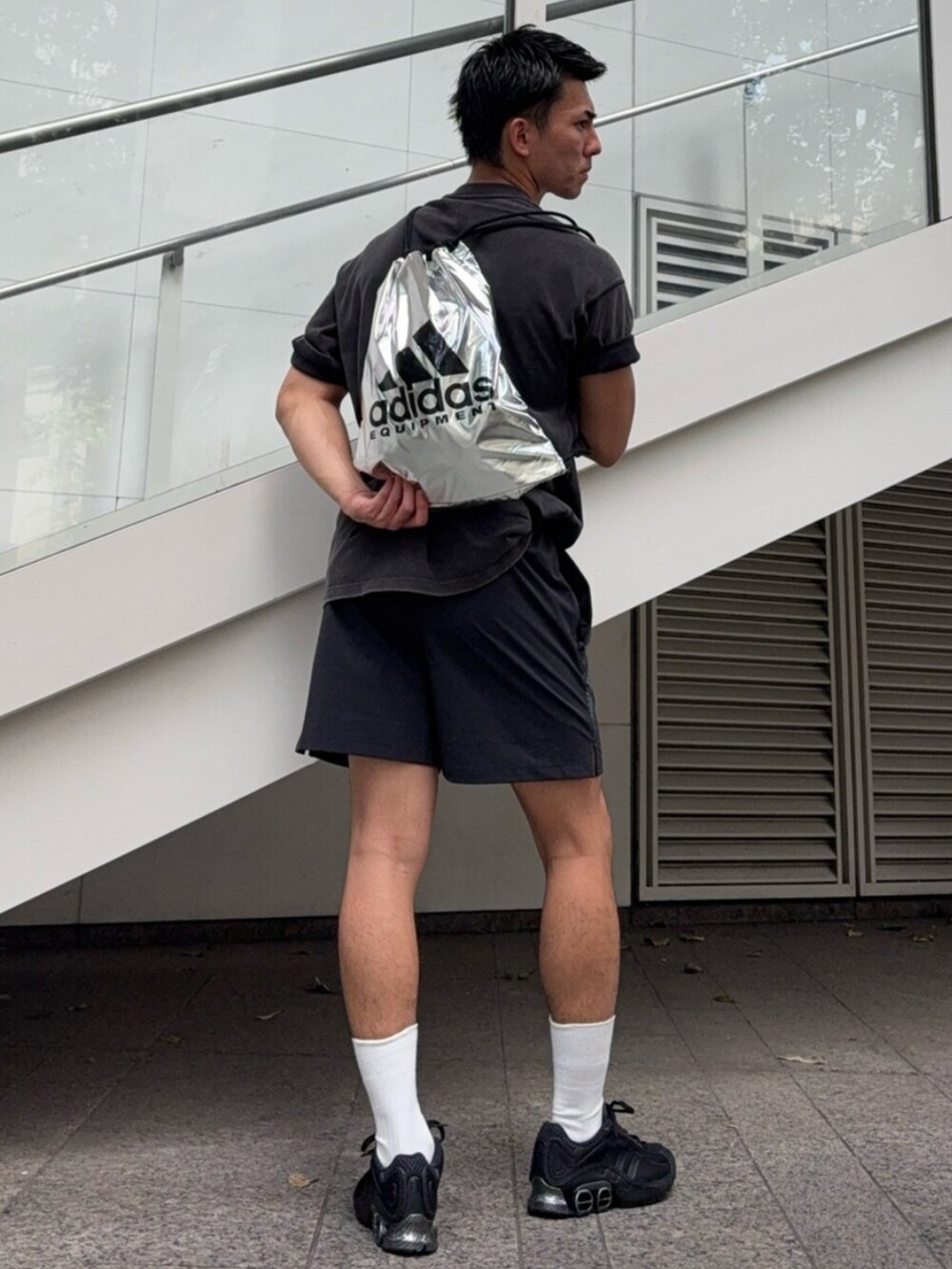 ブラック系のスニーカー、ブラック系のパンツ、ブラック系のトップスを着用したメンズの夏コーディネートの3枚目の写真