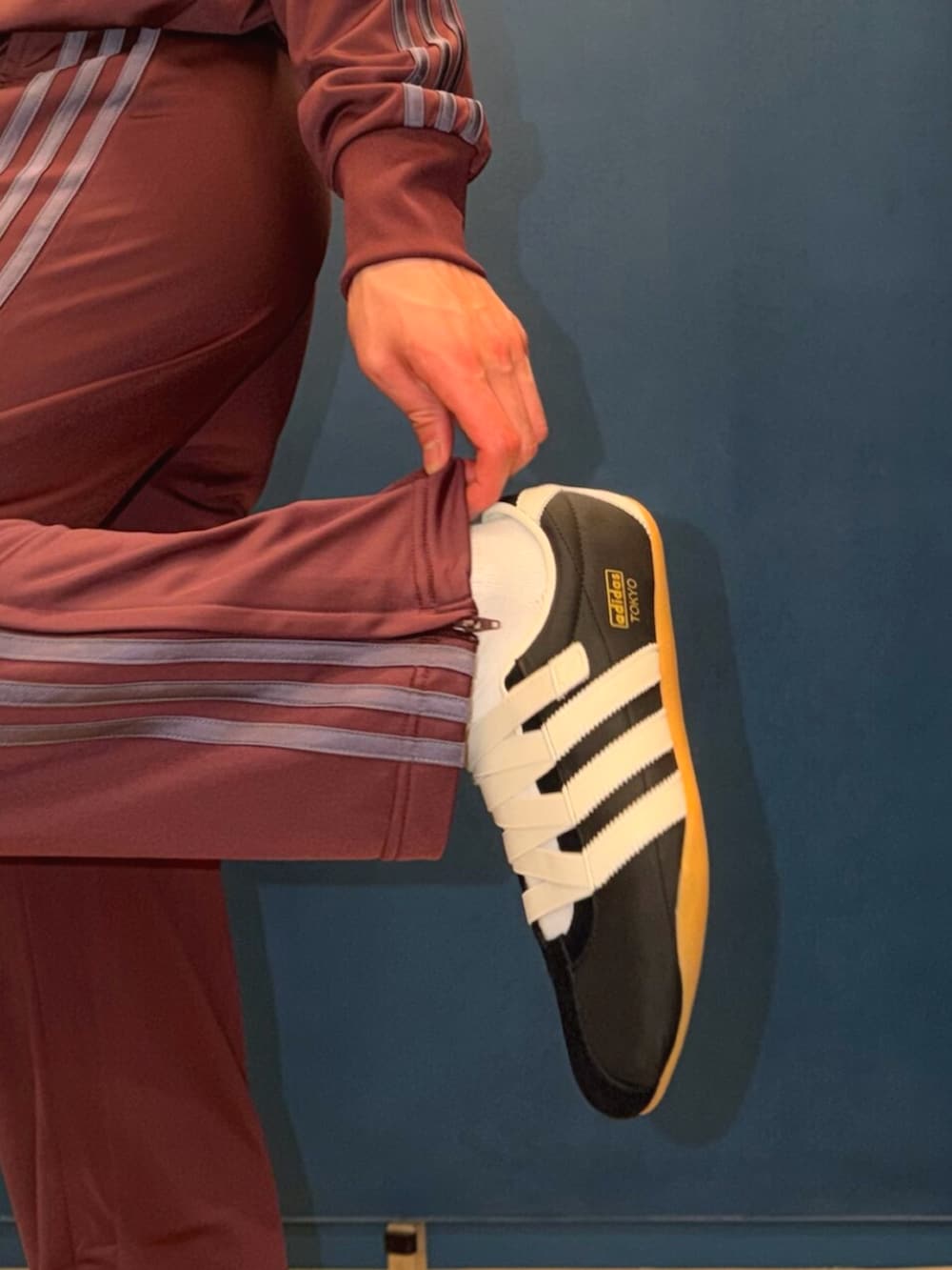 レッド系のトップス、レッド系のパンツ、ブラック系のスニーカーを着用したメンズの春コーディネートの4枚目の写真