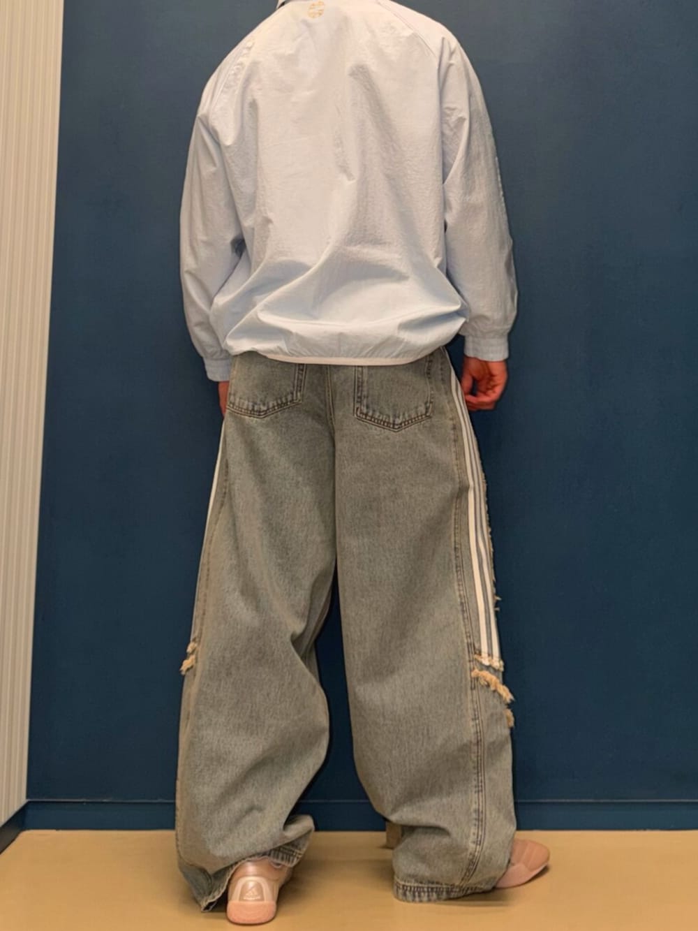 ブルー系のジャージ、ブルー系のデニムパンツ、ピンク系のシューズを着用したメンズの春コーディネートの3枚目の写真