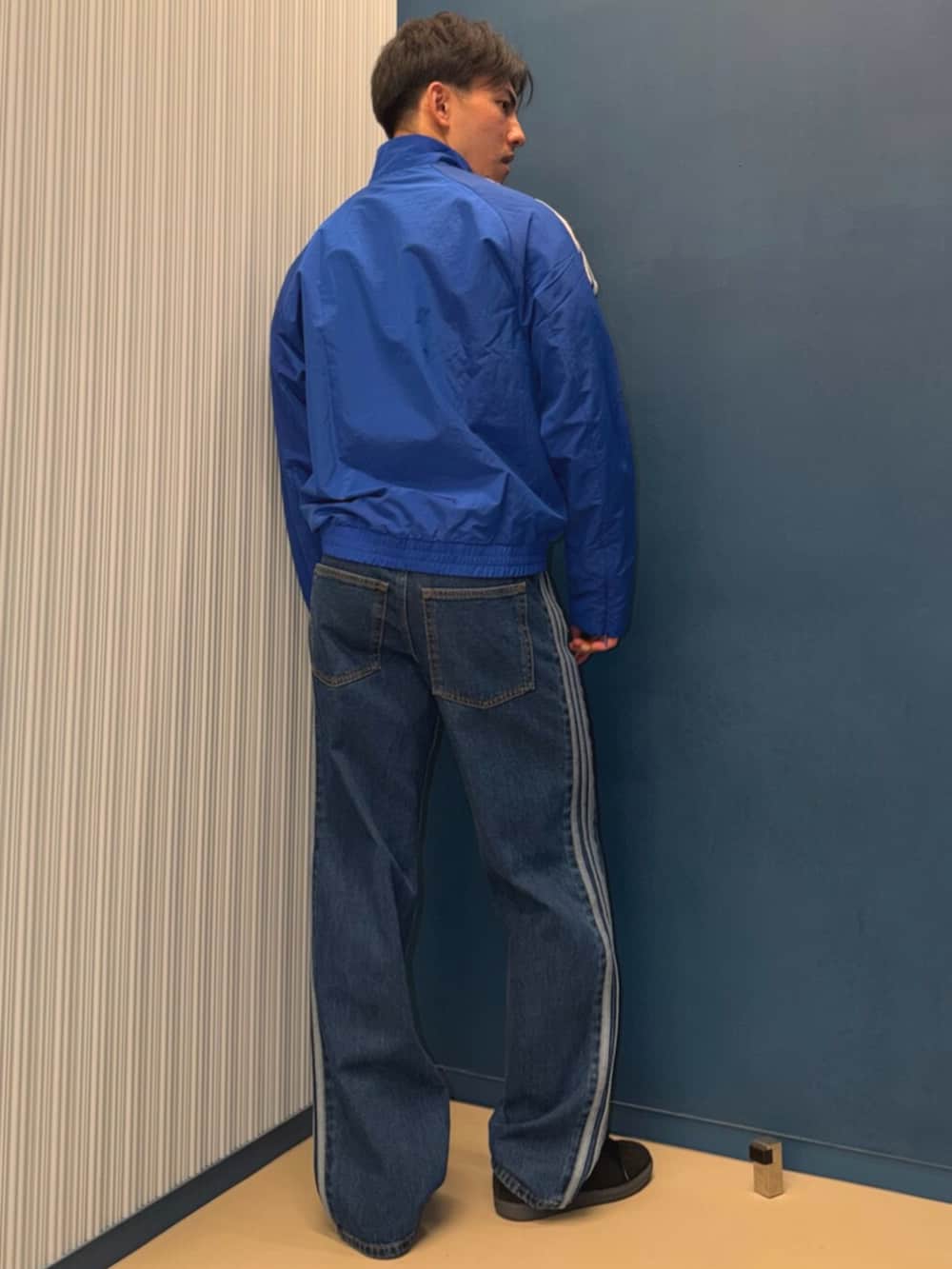 ブルー系のデニムパンツ、ブルー系のジャケット/アウター、ブラック系のスニーカーを着用したメンズの春コーディネートの2枚目の写真