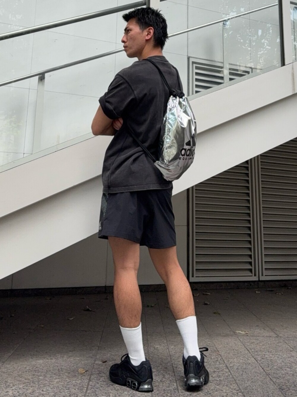 ブラック系のスニーカー、ブラック系のパンツ、ブラック系のトップスを着用したメンズの夏コーディネートの2枚目の写真