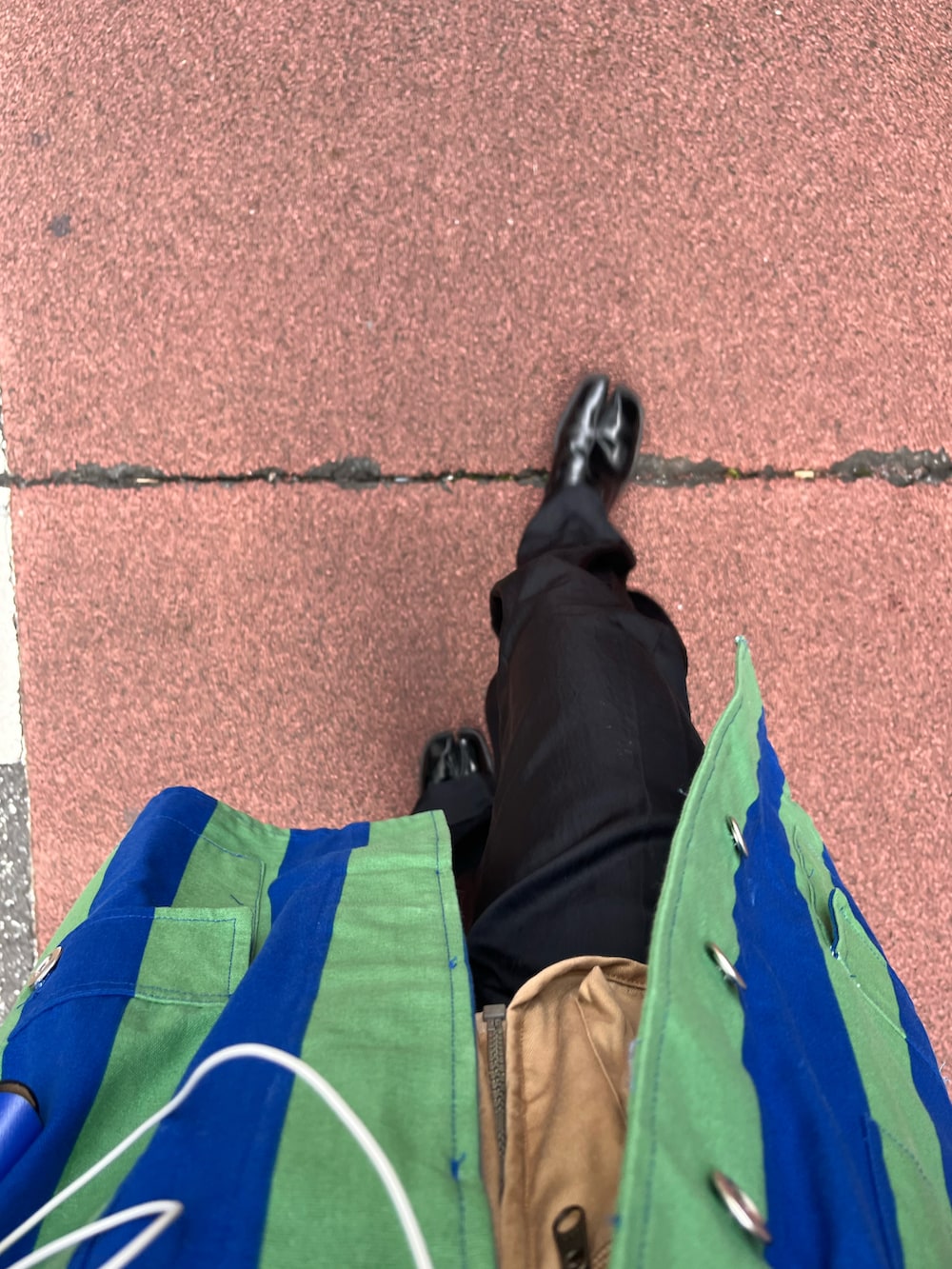 ベージュ系のベスト、グリーン系のシャツ/ブラウス、ブラック系のスラックスを着用したレディースの秋コーディネートの3枚目の写真