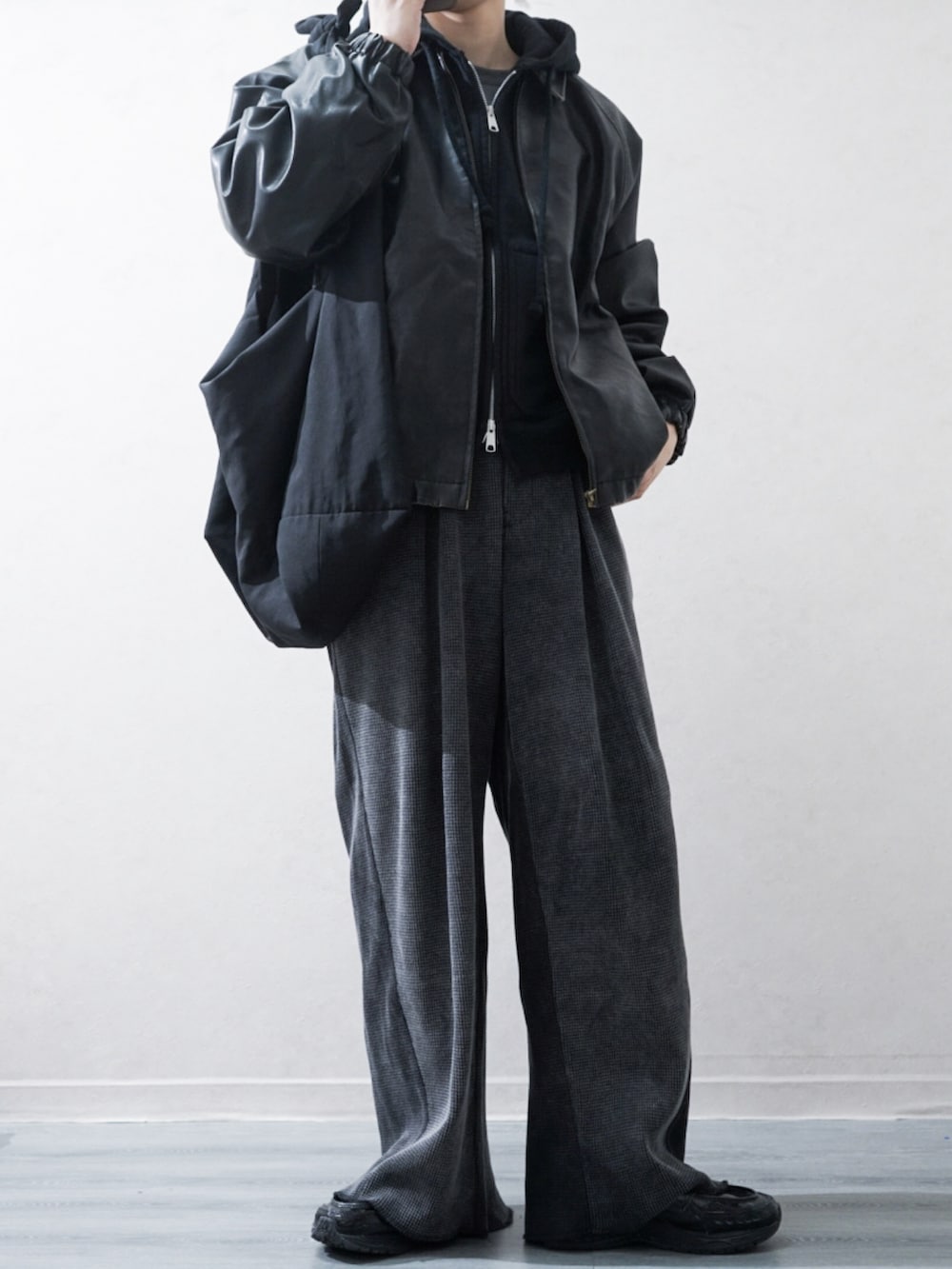 ブラック系のブルゾン、ブラック系のパーカー、グレー系のその他パンツを着用したメンズの冬コーディネートの2枚目の写真