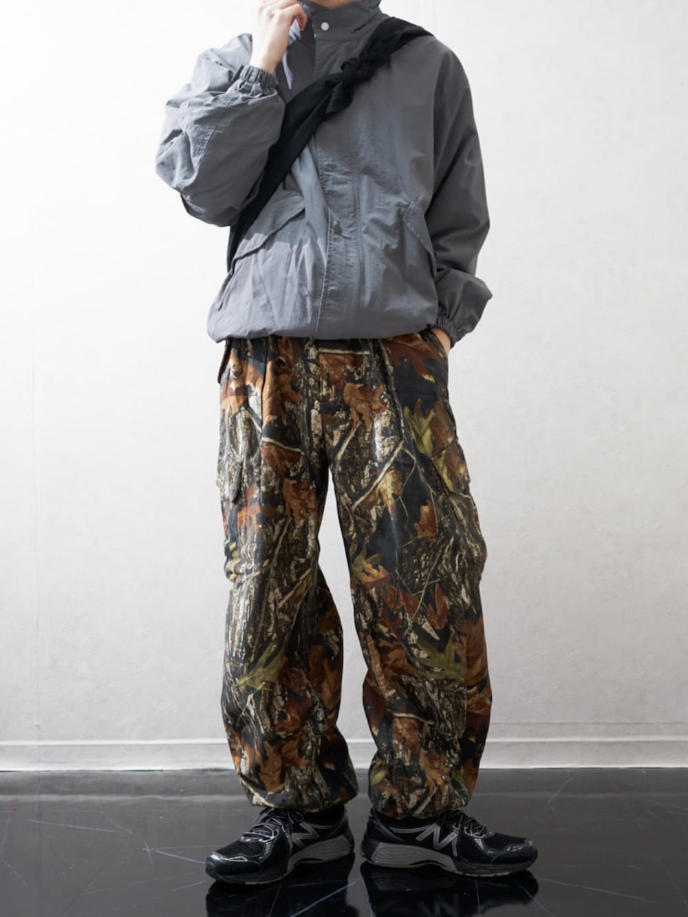 グレー系のモッズコート、ブラウン系のカーゴパンツ、ブラック系のスニーカーを着用したメンズの冬コーディネートの2枚目の写真