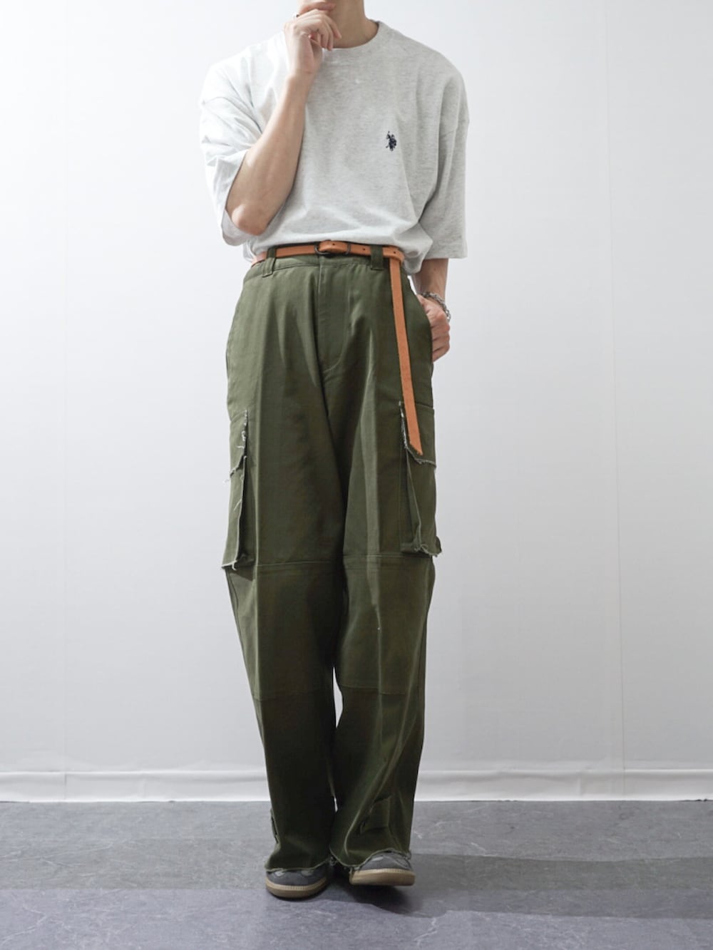 グリーン系のカーゴパンツ、グレー系のTシャツ/カットソー、グレー系のショルダーバッグを着用したメンズの春コーディネートの2枚目の写真