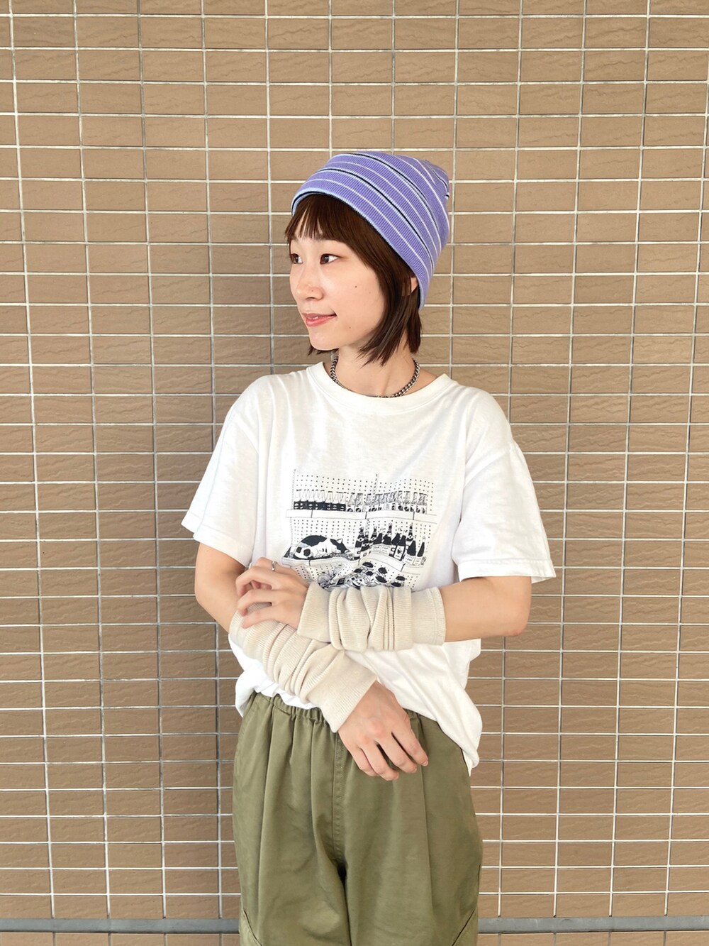 ホワイト系のTシャツ/カットソー、グリーン系のカーゴパンツ、ブラック系のブーツを着用したレディースの秋コーディネートの3枚目の写真