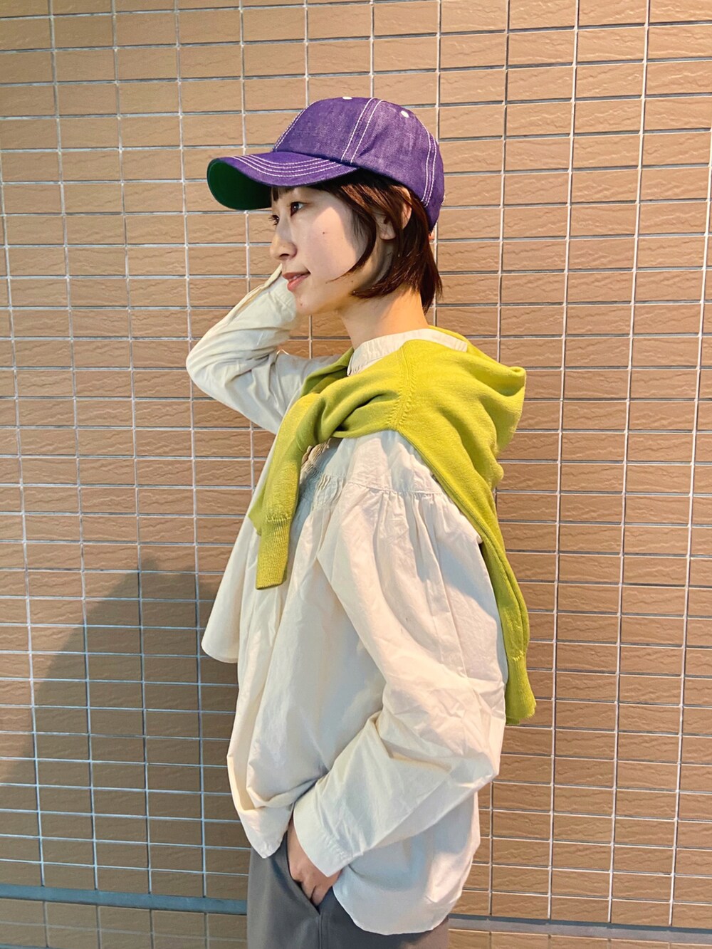 ベージュ系のシャツ/ブラウス、グリーン系のカーディガン/ボレロ、ブラック系のスニーカーを着用したレディースの冬コーディネートの2枚目の写真