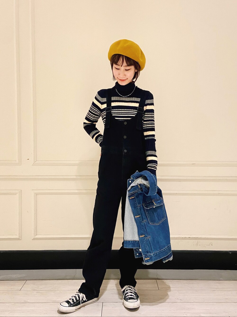 ブルー系のデニムジャケット、ブラック系のサロペット/オーバーオール、ブラック系のスニーカーを着用したレディースの冬コーディネートの2枚目の写真