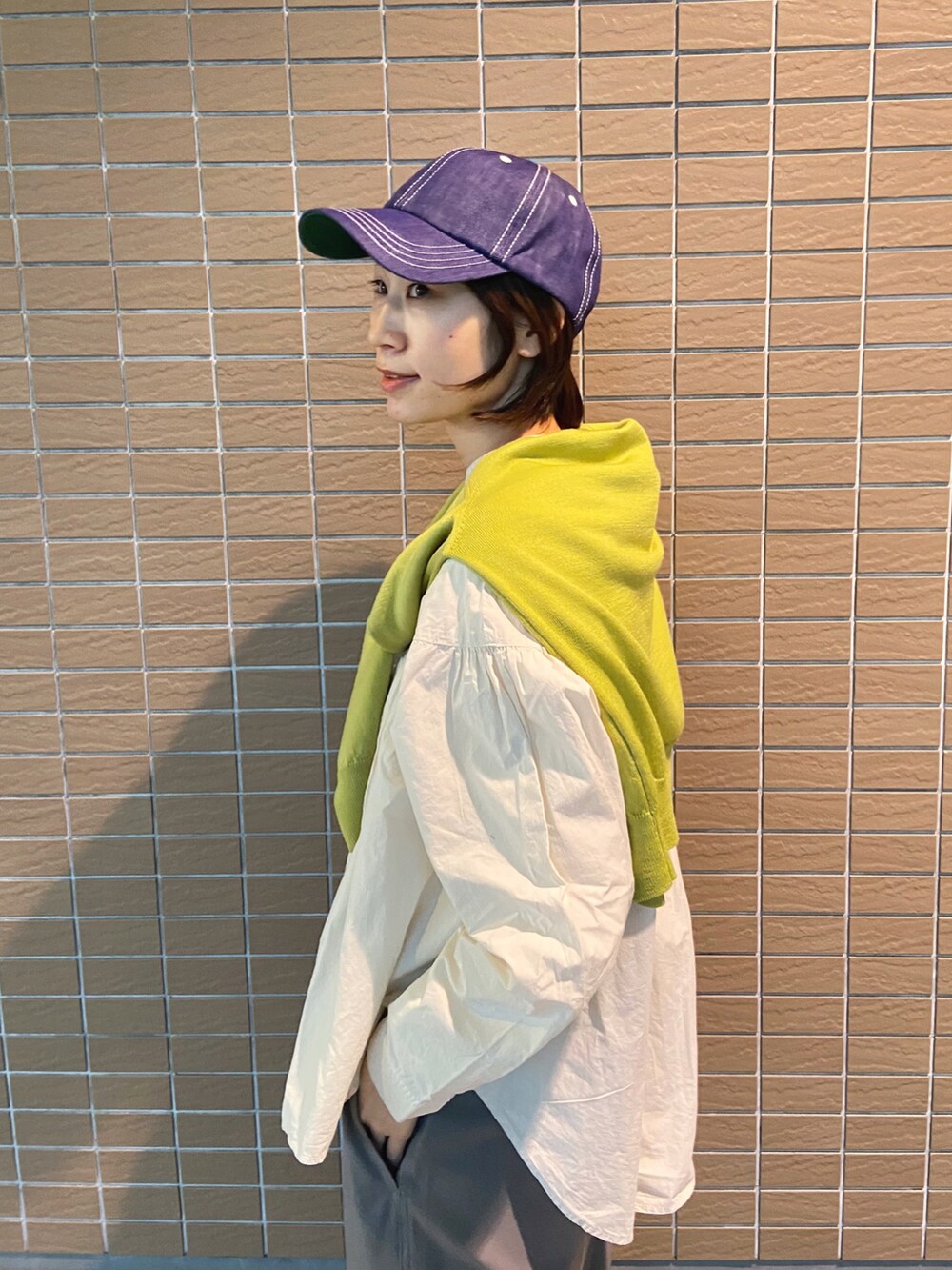 ベージュ系のシャツ/ブラウス、グリーン系のカーディガン/ボレロ、ブラック系のスニーカーを着用したレディースの冬コーディネートの3枚目の写真