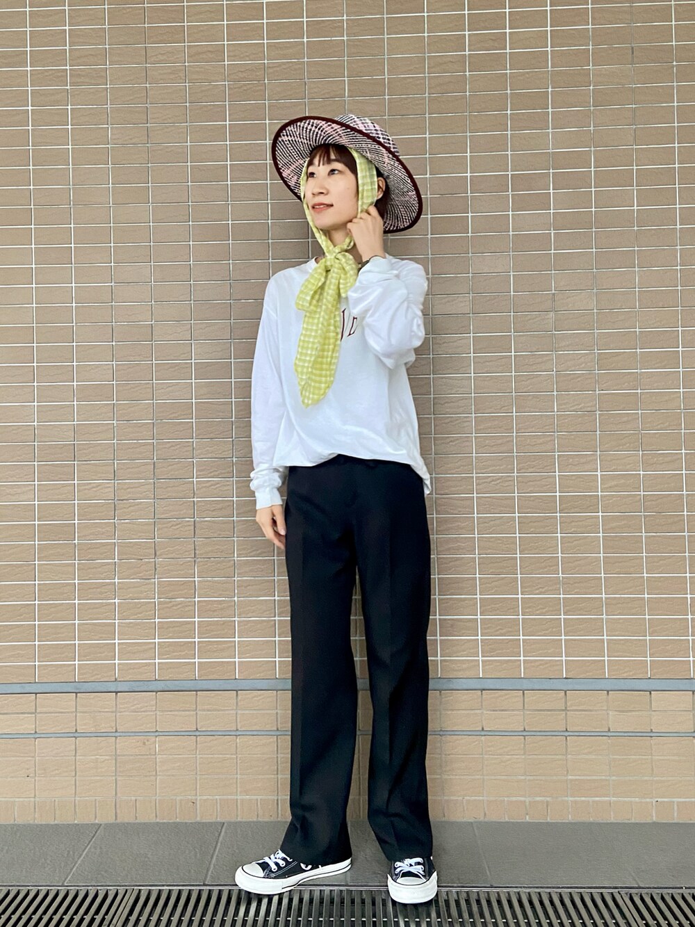 ホワイト系のTシャツ/カットソー、ブラック系のパンツ、ブラック系のスニーカーを着用したレディースの春コーディネートの2枚目の写真