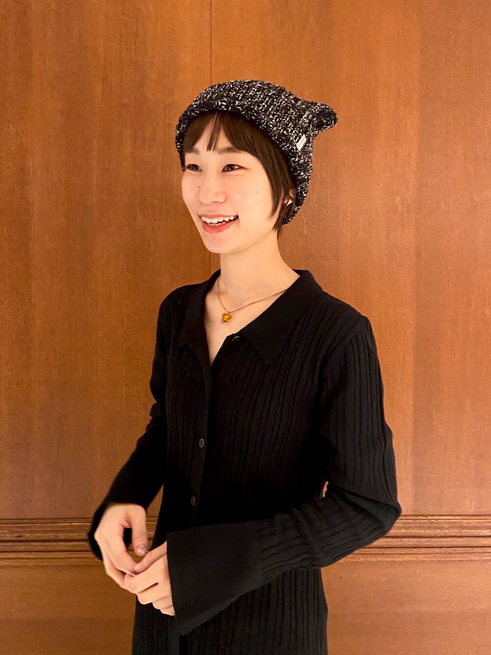 ブラック系のスニーカー、ブラック系のニットキャップ/ビーニー、ブラウン系のネックレスを着用したレディースの秋コーディネートの2枚目の写真