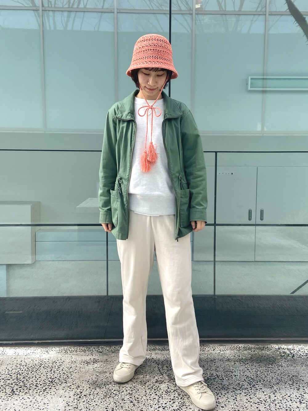 ホワイト系のスウェットパンツ、オレンジ系のハットを着用したレディースの春コーディネートの2枚目の写真