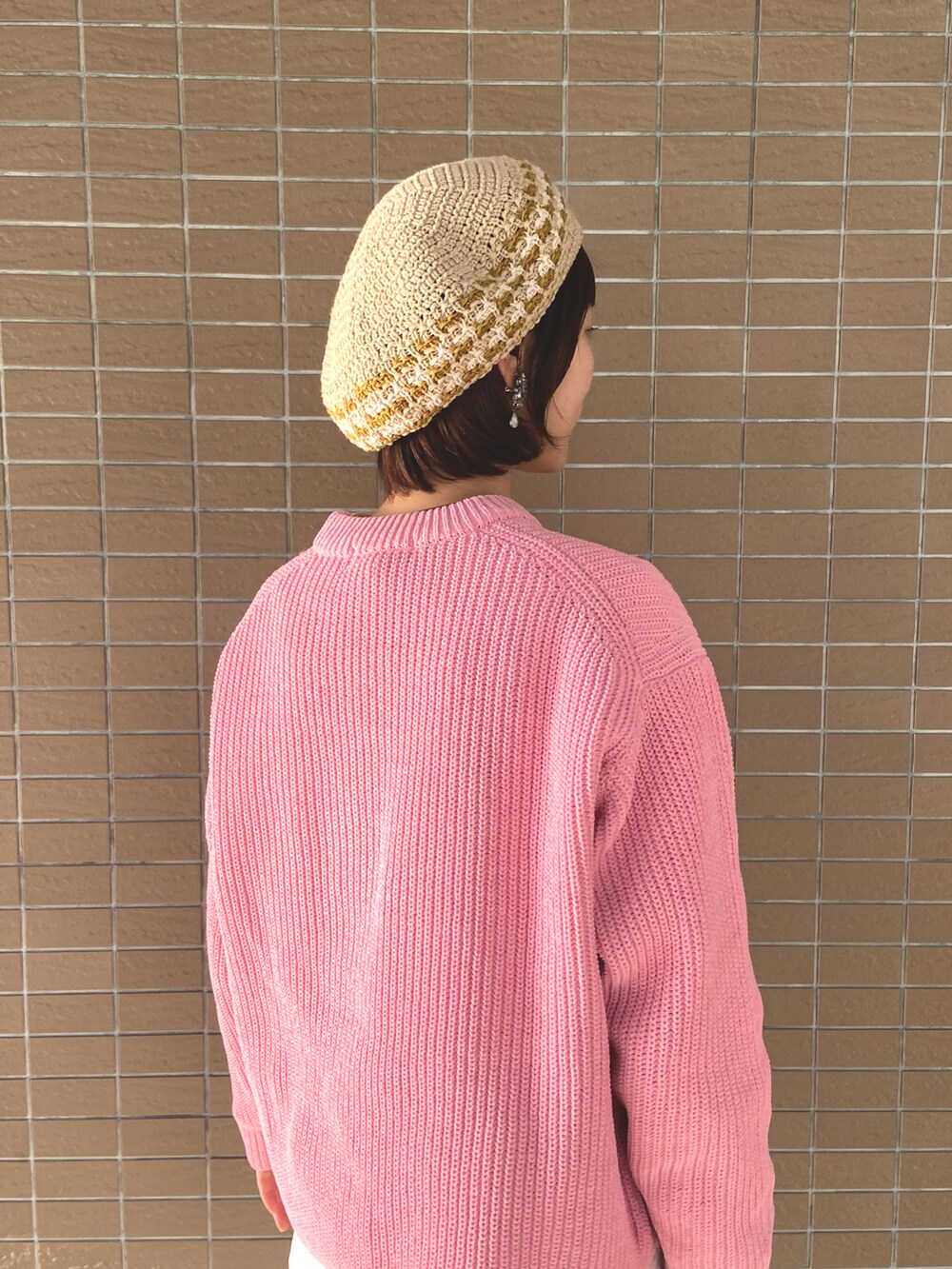 ホワイト系のスウェットパンツ、ベージュ系のスニーカー、ピンク系のニット/セーターを着用したレディースの冬コーディネートの3枚目の写真