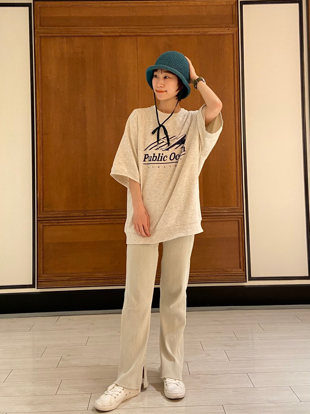 ベージュ系のTシャツ/カットソー、ベージュ系のスラックス、ホワイト系のスニーカーを着用したレディースの春コーディネートの2枚目の写真