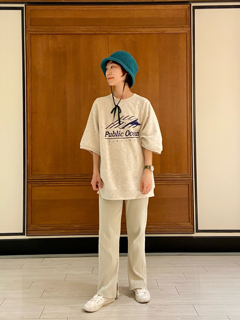 ベージュ系のTシャツ/カットソー、ベージュ系のスラックス、ホワイト系のスニーカーを着用したレディースの春コーディネートの3枚目の写真