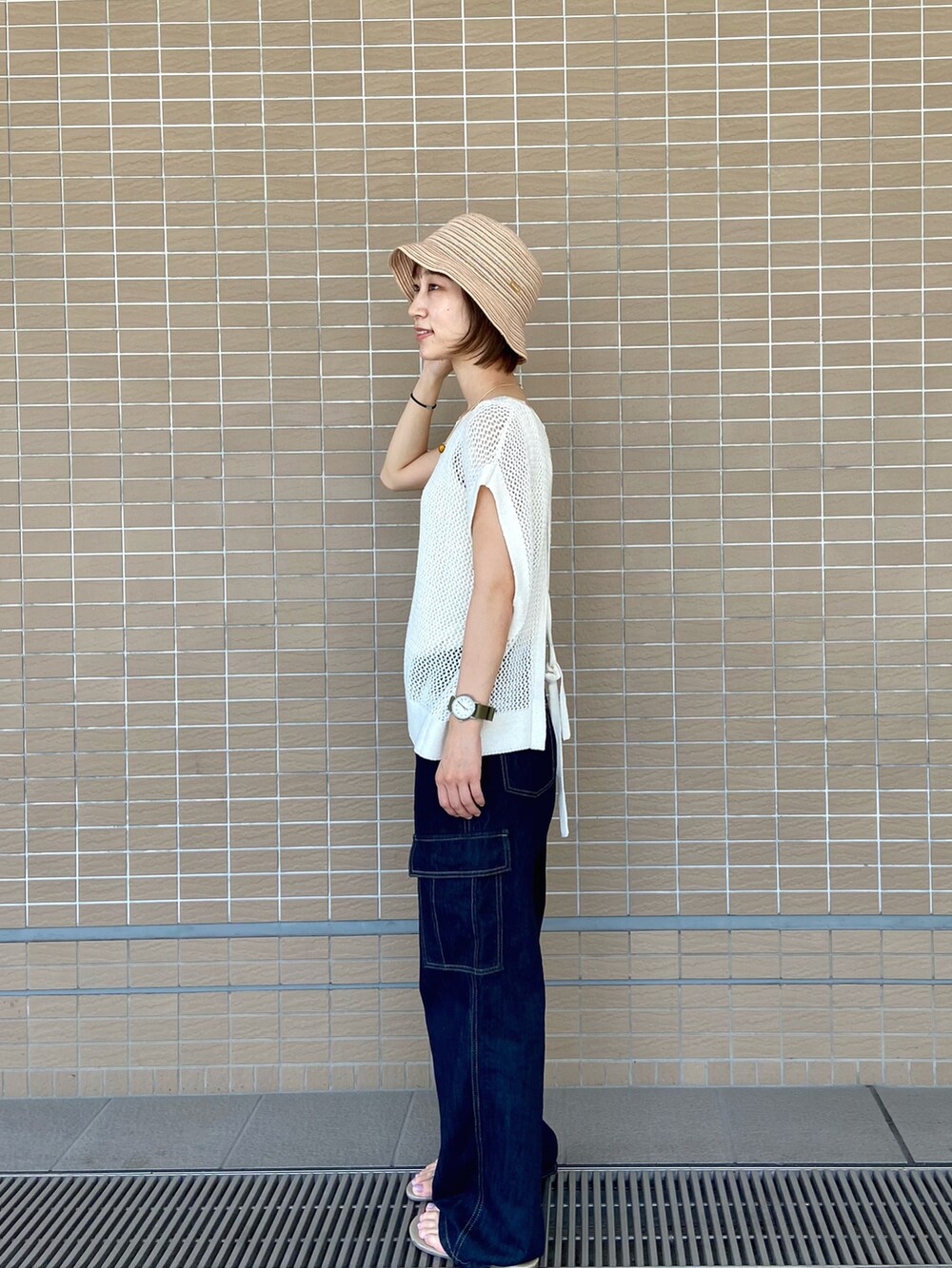 ホワイト系のタンクトップ、ベージュ系のサンダル、ベージュ系のハットを着用したレディースの夏コーディネートの2枚目の写真