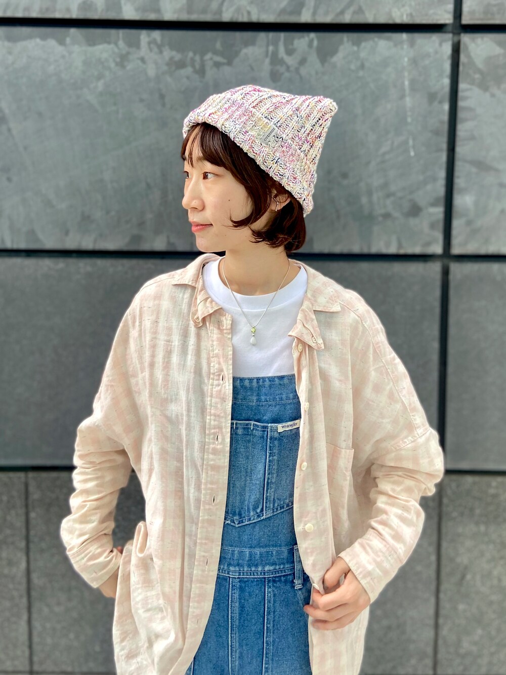 ブルー系のサロペット/オーバーオール、ベージュ系のスニーカー、ホワイト系のTシャツ/カットソーを着用したレディースの春コーディネートの2枚目の写真