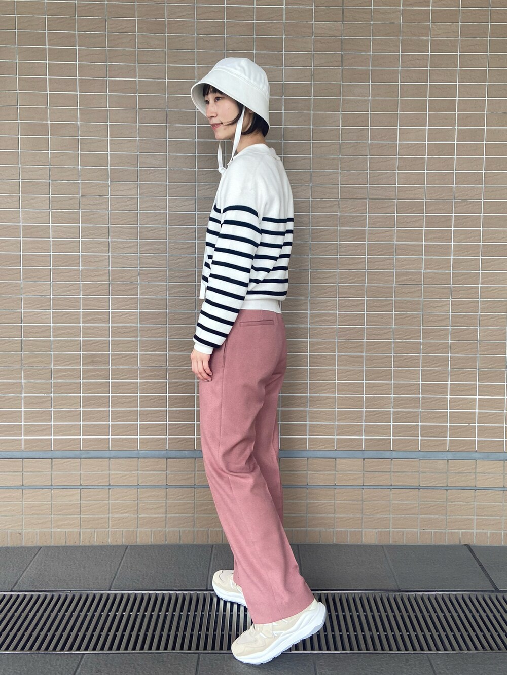 ピンク系のその他パンツ、ベージュ系のスニーカー、ホワイト系のニット/セーターを着用したレディースの冬コーディネートの2枚目の写真