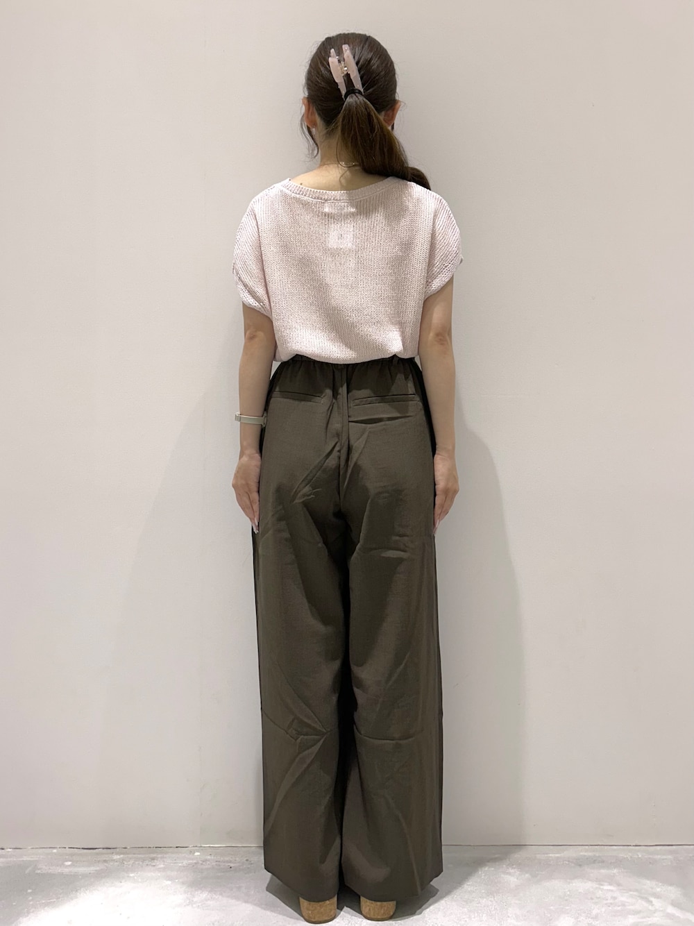 ピンク系のニット/セーター、ブラウン系のその他パンツ、ベージュ系のサンダルを着用したレディースの夏コーディネートの3枚目の写真