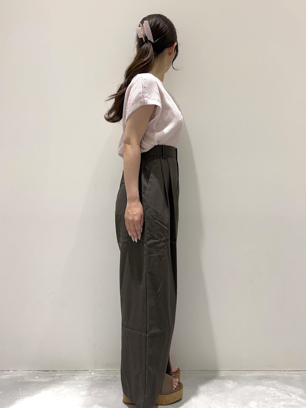 ピンク系のニット/セーター、ブラウン系のその他パンツ、ベージュ系のサンダルを着用したレディースの夏コーディネートの2枚目の写真