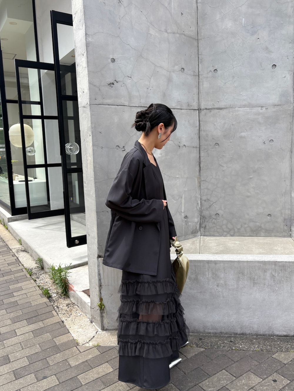 グレー系のドレス、イエロー系のショルダーバッグ、シルバー系のパンプスを着用したレディースの夏コーディネートの9枚目の写真