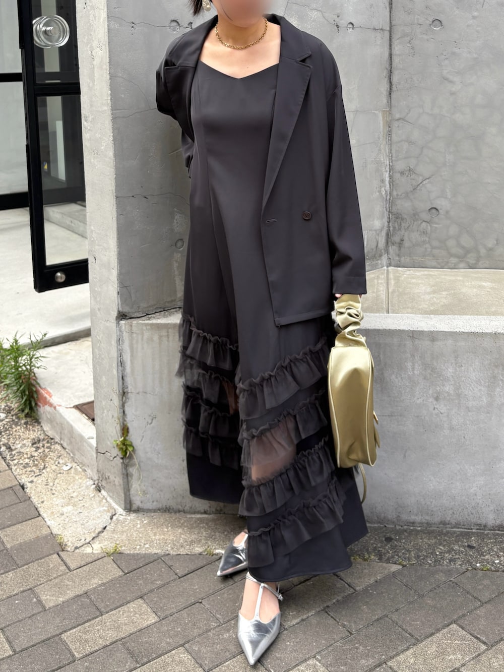 グレー系のドレス、イエロー系のショルダーバッグ、シルバー系のパンプスを着用したレディースの夏コーディネートの6枚目の写真