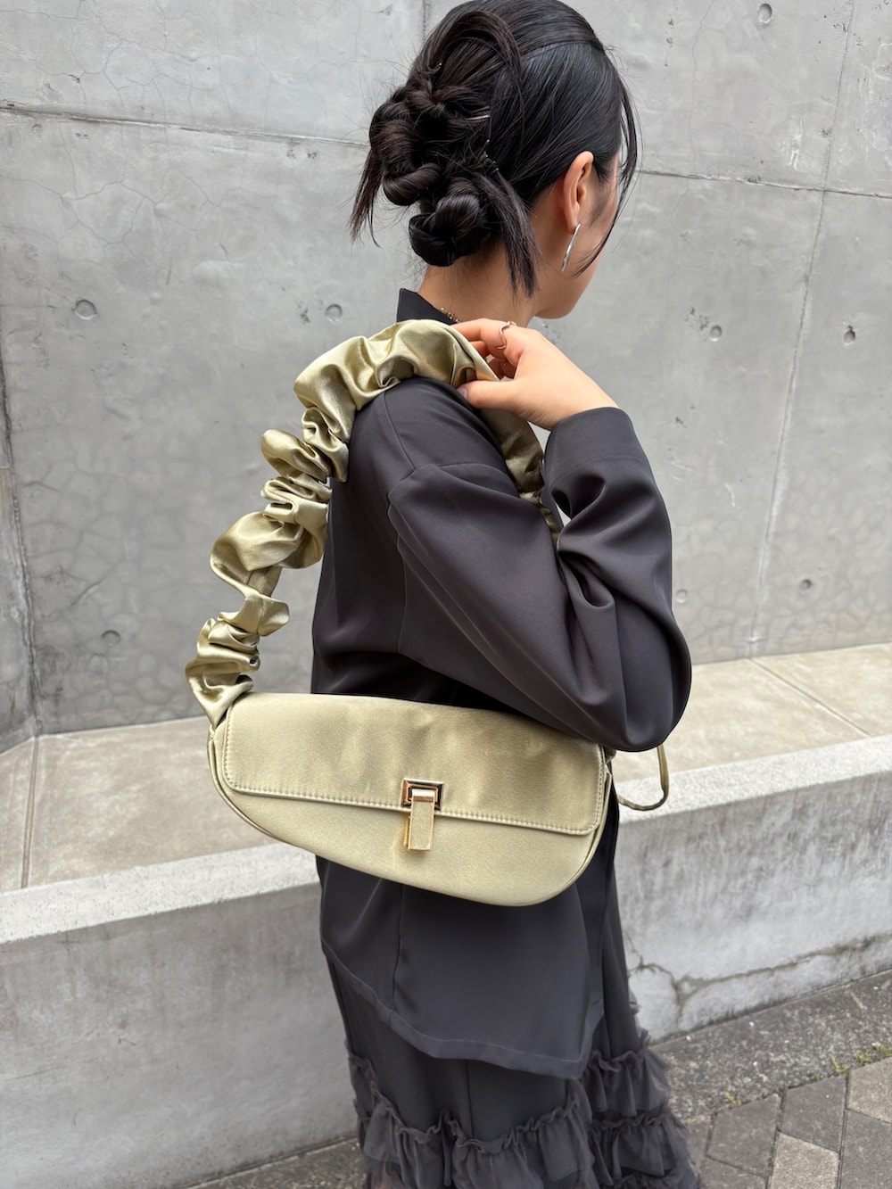 グレー系のドレス、イエロー系のショルダーバッグ、シルバー系のパンプスを着用したレディースの夏コーディネートの7枚目の写真