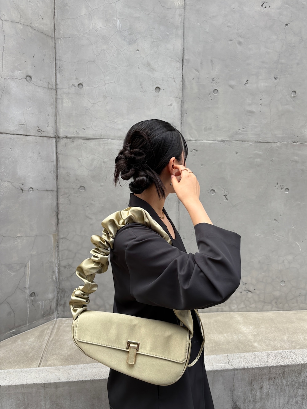 グレー系のドレス、イエロー系のショルダーバッグ、シルバー系のパンプスを着用したレディースの夏コーディネートの4枚目の写真