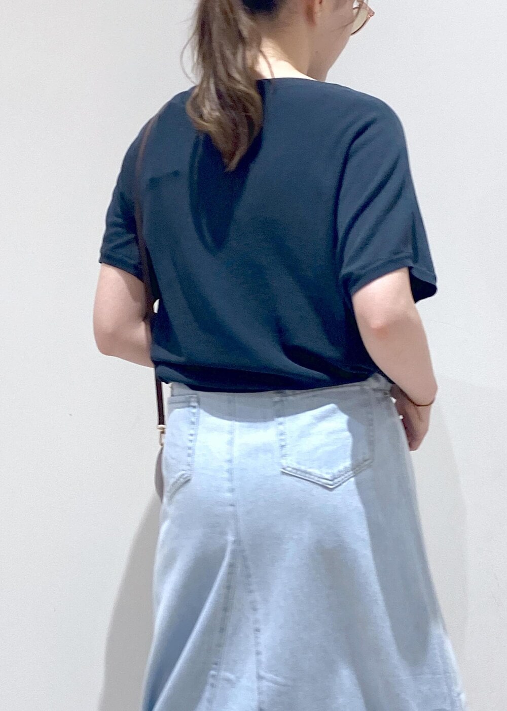 グレー系のショルダーバッグ、ブルー系のデニムスカート、グリーン系のニット/セーターを着用したレディースの夏コーディネートの7枚目の写真