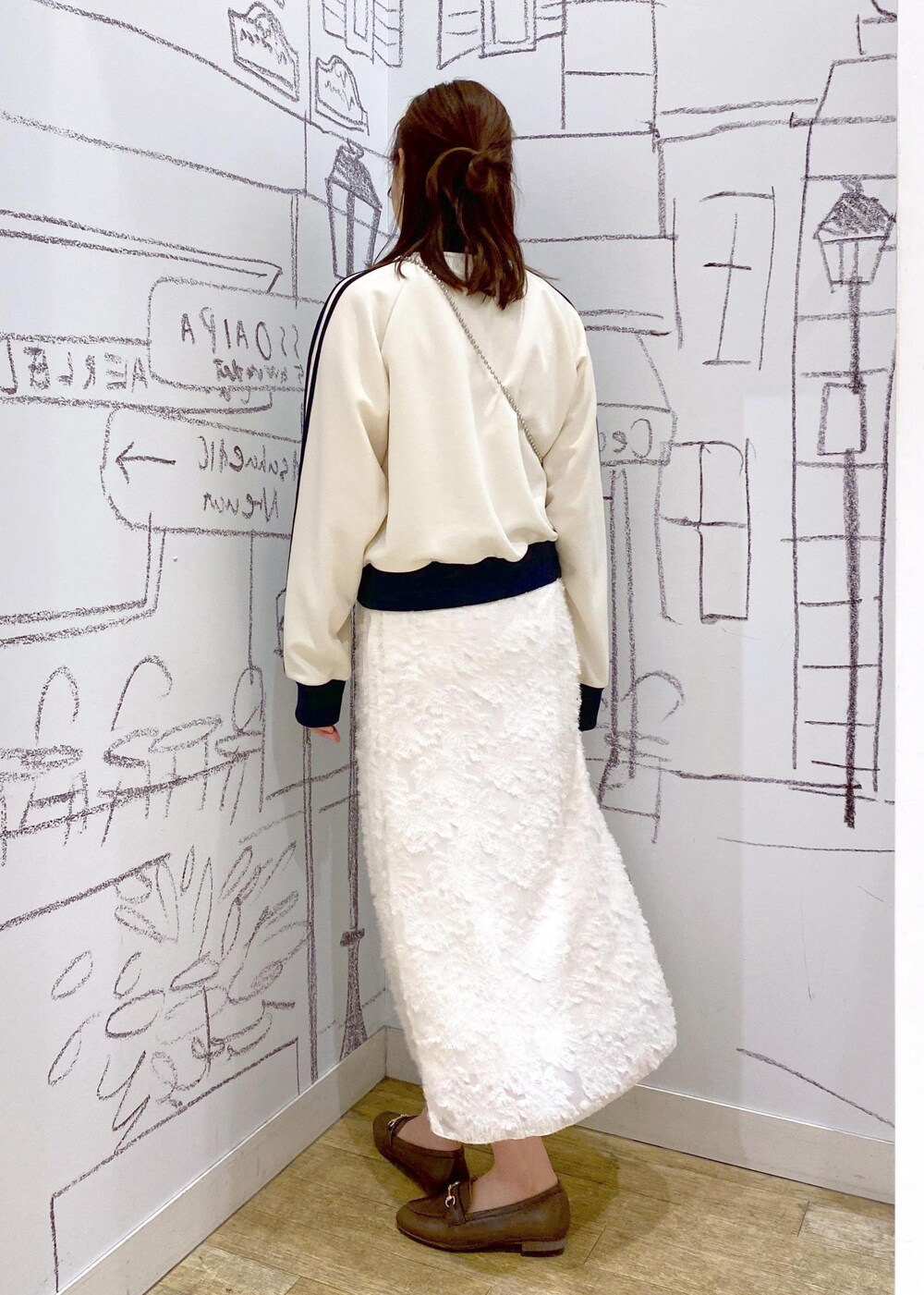 ホワイト系のスカート、ホワイト系のその他アウター、ブラウン系のローファーを着用したレディースの春コーディネートの2枚目の写真