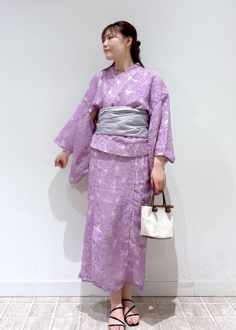 ブラック系のサンダル、ブラウン系のトートバッグ、パープル系の浴衣を着用したレディースの夏コーディネートの2枚目の写真