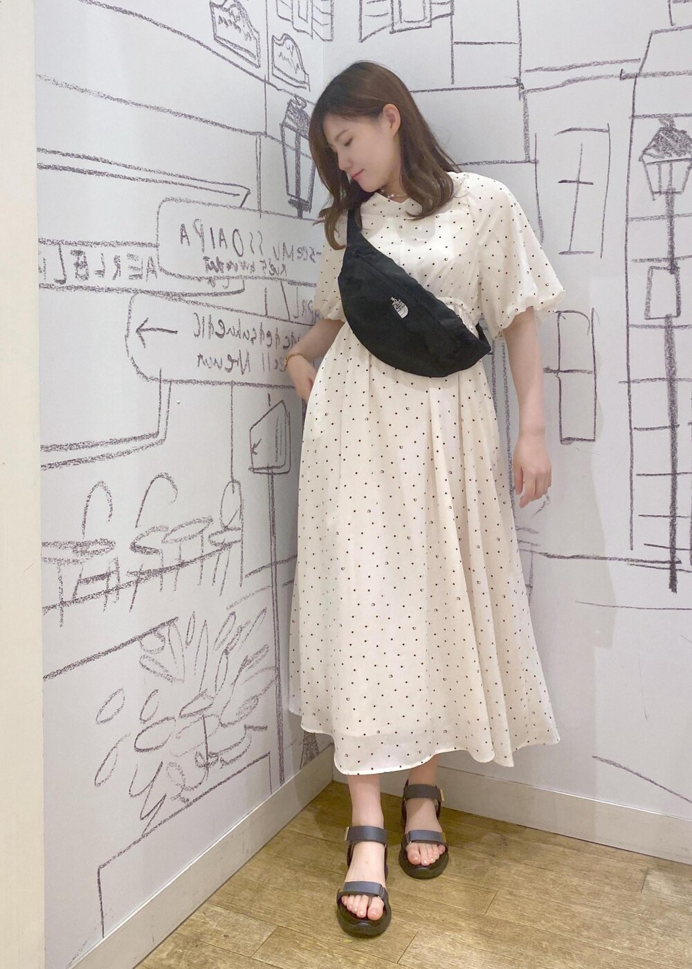 ブラック系のボディバッグ/ウエストポーチ、ブルー系のサンダル、ホワイト系のワンピースを着用したレディースの春コーディネートの3枚目の写真