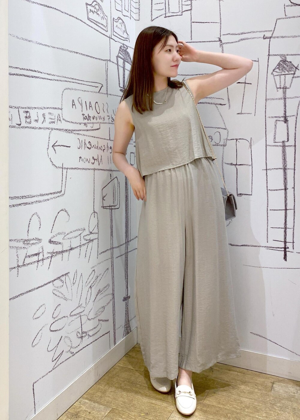 ベージュ系のつなぎ/オールインワン、ホワイト系のローファー、グレー系のショルダーバッグを着用したレディースの夏コーディネートの2枚目の写真