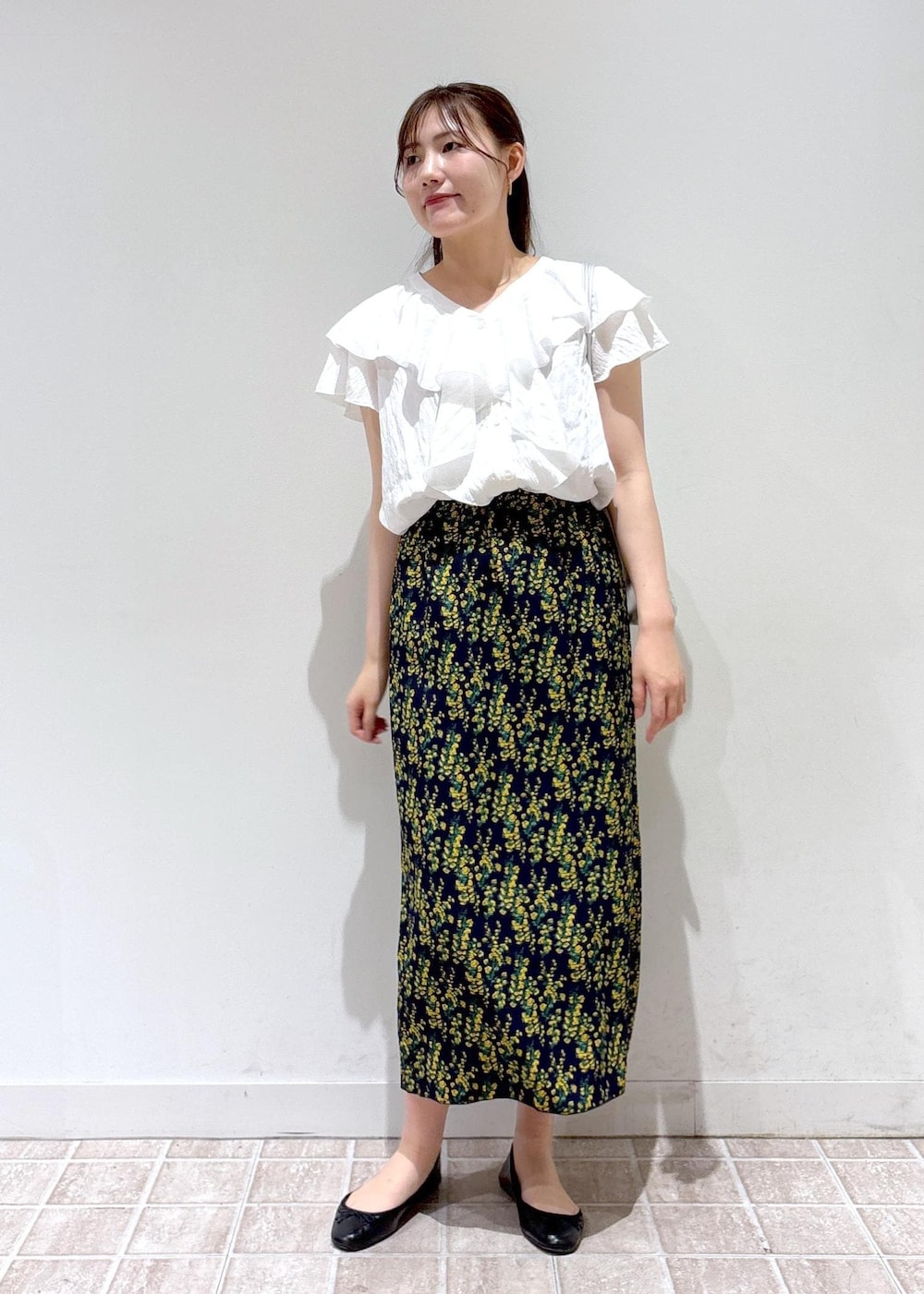 ブラック系のバレエシューズ、シルバー系のトートバッグ、ブルー系のスカートを着用したレディースの夏コーディネートの2枚目の写真